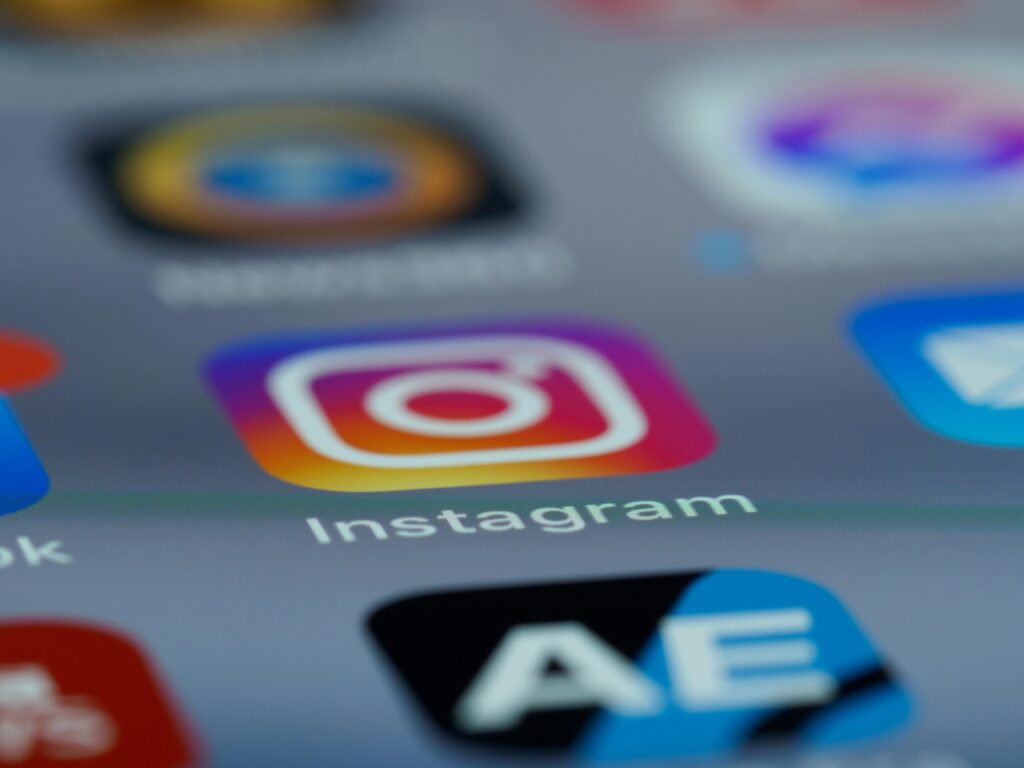 Instagram app icon in focus on a smartphone screen, blurred background.